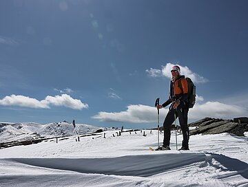 Eine Wanderin posiert vor idyllischem Alpenszenerie. 